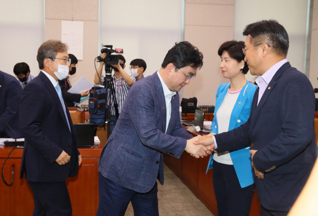 윤호중 국회 법사위원장(오른쪽 부터)과 더불어민주당 백혜련 간사, 김종민 의원 등이 29일 국회 법제사법위원회 전체회의에서 미래통합당 의원들이 퇴장한 가운데 주택임대차보호법 개정안 등 부동산 관련 법안을 의결한 뒤 악수하고 있다. 연합뉴스
