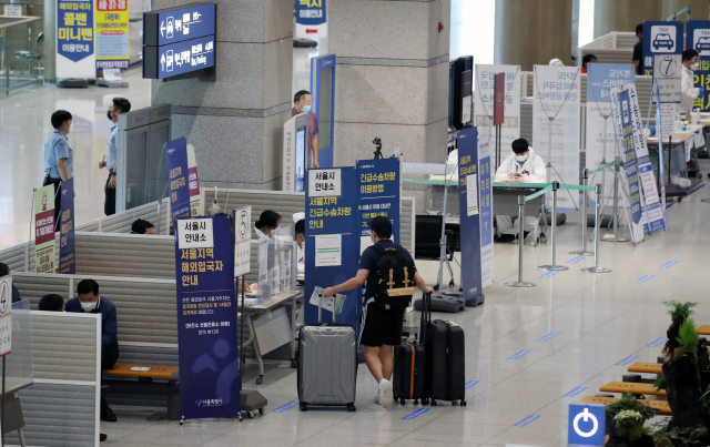 29일 영종도 인천국제공항 제1터미널 입국장에서 해외입국자들이 신종 코로나바이러스 감염증(코로나19) 관련 안내를 받고 있다. 연합뉴스