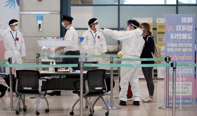 29일 영종도 인천국제공항 제1터미널 입국장에서 해외입국자들이 신종 코로나바이러스 감염증(코로나19) 관련 안내를 받고 있다. 연합뉴스
