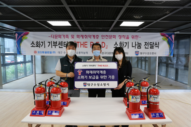 이광성(가운데) 대구 수성소방서장과 석동훈(왼쪽) ㈜코오롱글로벌 현장소장, 이정은(오른쪽) 수성구다문화가족지원센터 총괄실장이 중고소화기 기부행사를 가진 뒤 기념촬영을 하고 있다. 수성소방서 제공