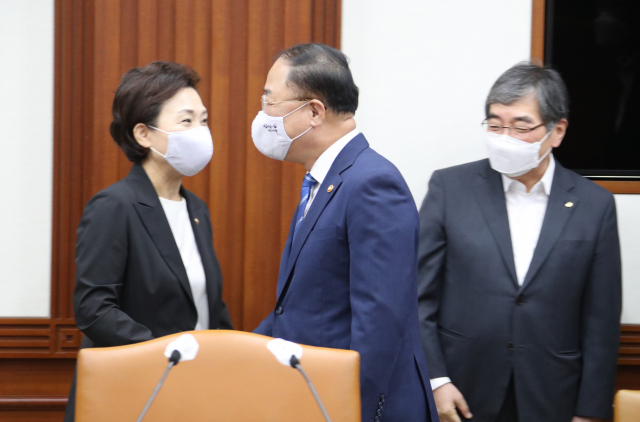 12일 정부서울청사에서 열린 제2차 부동산시장 점검 관계장관회의에 참석한 홍남기 부총리 겸 기재부 장관이 김현미 국토부 장관과 윤석헌 금융감독원장(오른쪽)과 인사하고 있다. 연합뉴스