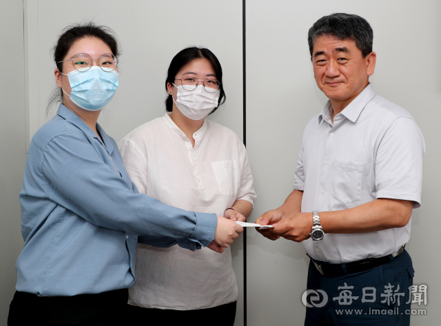 계명대학교 창업동아리 아우름의 채인영 회장(가운데)과 이정현 팀원(왼쪽)이 마스크 파우치 판매 수익금을 매일신문 이동관 편집국장(오른쪽)에게 전달하고 있다 . 성일권 기자 sungig@imaeil.com