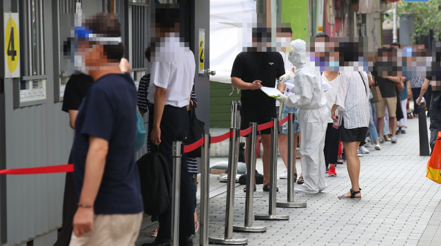 18일 오전 서울 성북구보건소에 마련된 신종 코로나바이러스감염증(코로나19) 임시 선별진료소를 찾은 시민들이 검사 순서를 기다리고 있다. 연합뉴스