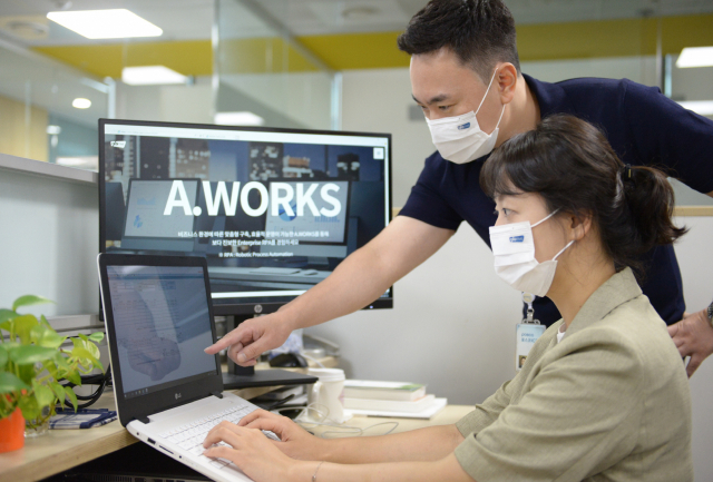 포스코ICT 직원들이 자체개발한 에이웍스( A.WORKS)를 적용해 업무를 자동으로 처리한 결과를 확인하고 있다. 포스코ICT 제공