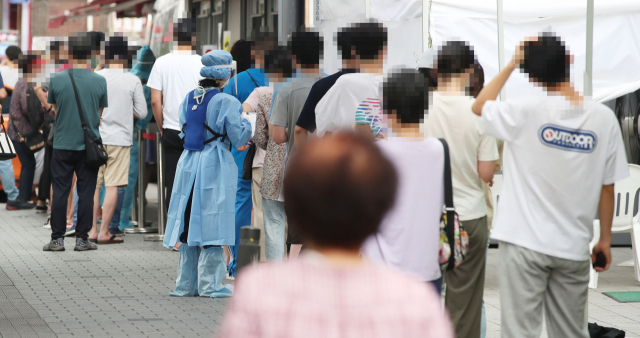 21일 오전 서울 성북구보건소에 마련된 신종 코로나바이러스 감염증(코로나19) 선별진료소를 찾은 시민들이 검사받기 위해 줄을 서고 있다. 연합뉴스