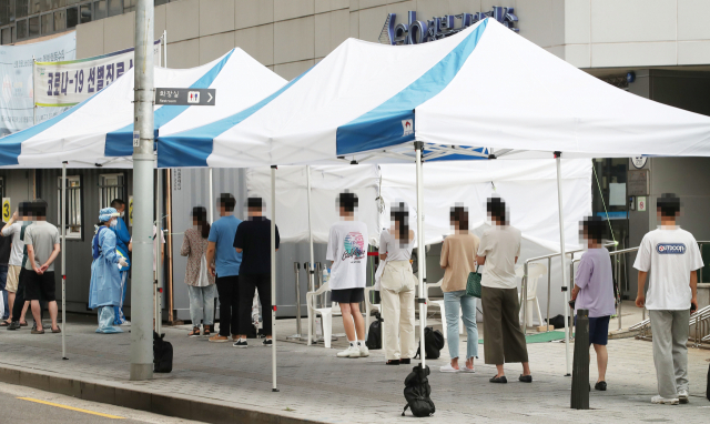 21일 오전 서울 성북구보건소에 마련된 신종 코로나바이러스 감염증(코로나19) 선별진료소를 찾은 시민들이 검사받기 위해 줄을 서고 있다. 연합뉴스