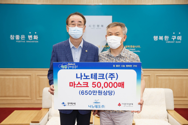 경북 구미 공단동의 김정헌(오른쪽) 나노테크㈜ 대표가 26일 장세용 구미시장에게 코로나19 예방용 마스크 5만 장을 기탁하고 있다. 구미시 제공