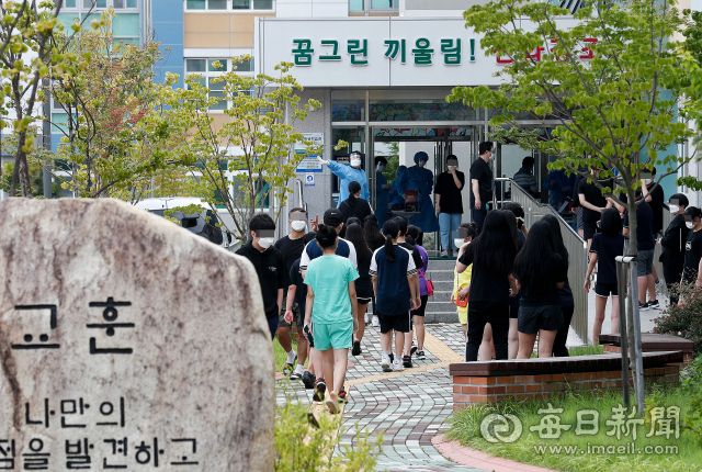 27일 오전 대구 동구 신아중학교 학생들이 교내에서 코로나19 진단 검사를 받기 위해 차례를 기다리고 있다. 학교측과 방역당국은 재학생 2명이 코로나19 양성 판정을 받게 됨에 따라 학교 시설을 폐쇄하고 전체 학생과 교직원에 대해 진단검사를 실시했다. 우태욱 기자 woo@imaeil.com