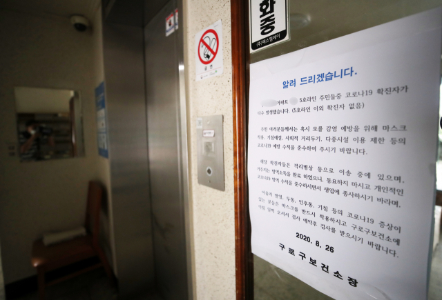 코로나19 확진자가 발생한 서울 구로구의 한 아파트에 27일 관련 안내문이 붙어 있다. 연합뉴스