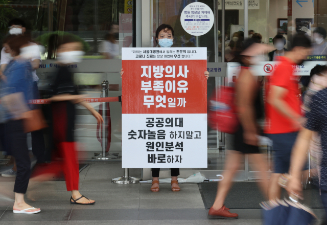 정부의 보건의료정책에 반대하는 대한의사협회의 집단휴진 이틀째인 27일 서울 종로구 서울대학교병원에서 전문의가 팻말을 들고 1인 시위를 이어가고 있다. 연합뉴스