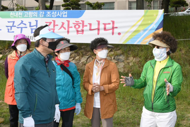 김문오 대구 달성군수가 생태공원으로 변모한 천내천에서 산책나온 지역주민들을 만나 담소를 나누고 있다. 달성군 제공