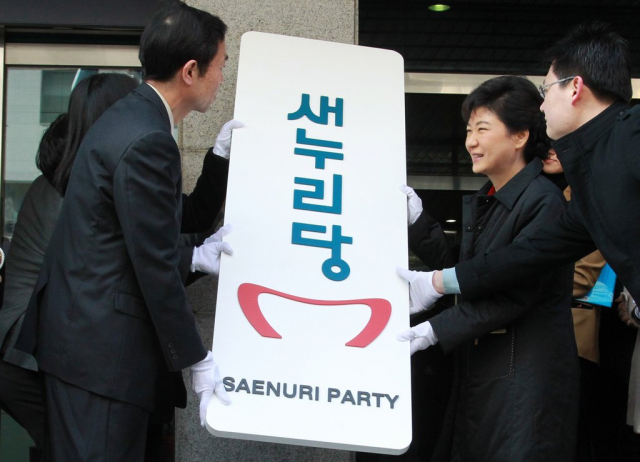 박근혜 당시 새누리당 비상대책위원장이 2012년 2월 16일 오전 여의도 새누리 당사에서 열린 새누리당 현판식에서 당명 제안자인 김성준, 최유경 씨와 함께 새당명이 새겨진 현판을 당사 벽에 걸고 있다. 연합뉴스