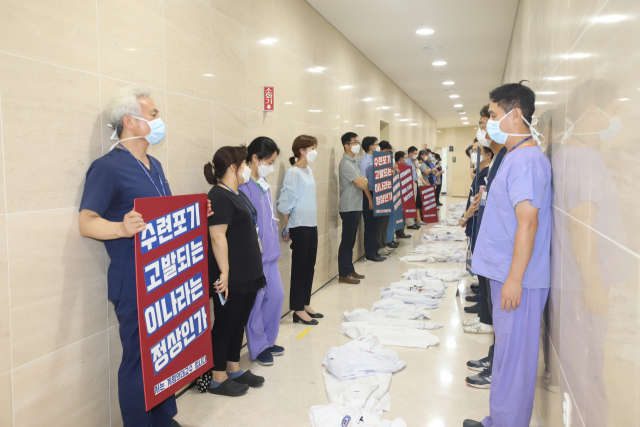 31일 계명대학교 동산병원 교수들이 전공의 근무 여부를 조사하러 나온 보건복지부 실사단에게 피켓시위를 하면서
