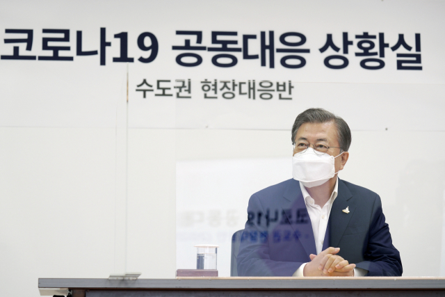 문재인 대통령이 지난 28일 서울 중구 국립중앙의료원 수도권 병상 공동대응 상황실에서 주영수 국립중앙의료원 기획조정실장으로부터 중증 병상 확보 현황을 보고받고 있다. 연합뉴스