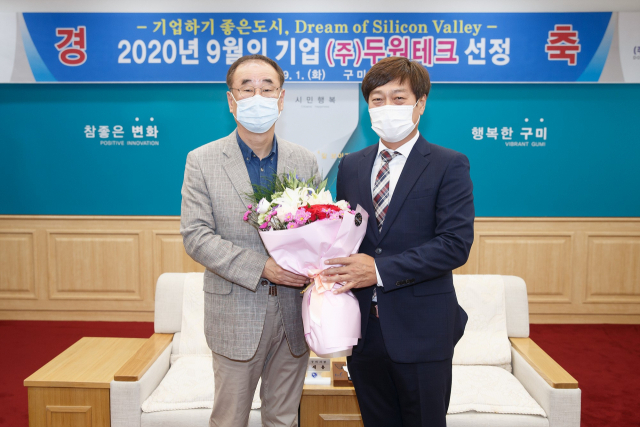 장세용(왼쪽) 구미시장이 9월 이달의 기업으로 선정된 이대원 ㈜두원테크 대표에게 축하의 꽃다발을 전하고 있다. 구미시 제공