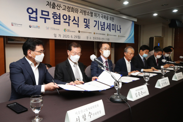 지난 6월 29일 오후 서울 중구 프레스센터에서 열린 저출산·고령화와 지방소멸 위기 극복을 위한 업무 협약식 및 기념 세미나에서 서형수 대통령직속 저출산고령사회위원회 위원장(왼쪽 첫번째) 등 관계자들이 업무협약서에 서명하고 있다. 연합뉴스