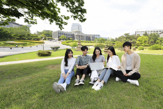 경북대 캠퍼스 잔딧밭에 앉아 있는 학생들. 뒤쪽으로 본관이 보인다. 경북대 제공