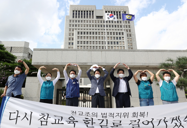 권정오 전국교직원노동조합 위원장(가운데)과 조합원 등이 3일 오후 서초동 대법원 앞에서 선고 뒤 열린 기자회견에서 기쁨을 표현하고 있다. 연합뉴스