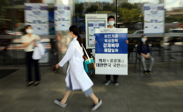 4일 오전 서울대학교병원에서 보건의료 정책에 반대하는 의사들이 일인시위를 하고 있다. 대한의사협회가 더불어민주당과 공공의료 확충 정책 입법을 재검토하기로 최종 합의한 현재 서울대병원 앞에서 하던 일인시위는 멈춘 상태다. 연합뉴스