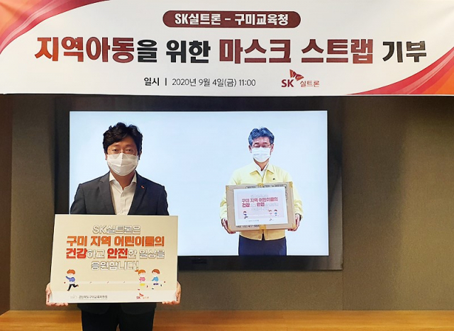 구미산단 내 ㈜SK실트론의 이영석(왼쪽) SV추진담당이 신동식 구미교육장에게 비대면 온라인 방식으로 마스크 스트랩 4만개를 전달하고 있다. SK실트론 제공