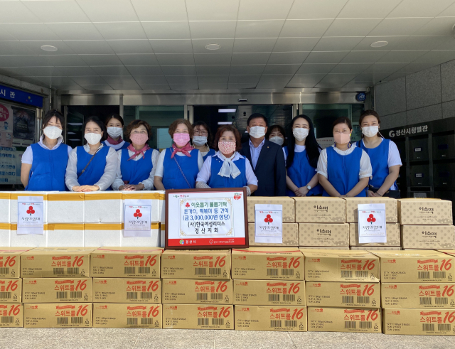 (사)한국여성리더스 경산지회 정인숙 지회장과 회원들이 4일 지역아동센터에 떡볶이, 돈가스, 과자 등 간식 300만원 상당을 전달했다.