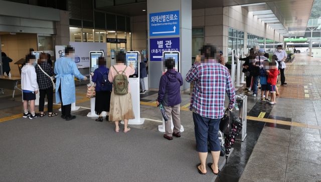 단체행동을 잠정 중단하고 업무에 복귀하기로 했던 전공의들이 계속해서 집단휴진을 이어가고 있는 7일 오전 서초구 서울성모병원에서 내원객들이 입장 전 사전 문진표를 작성하고 있다. 연합뉴스