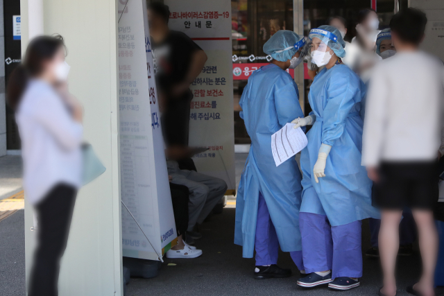 4일 오전 광주 동구 전남대학교병원 선별진료소에서 의료진이 코로나19 진단검사 절차를 안내하고 있다. 광주에서는 전날 자정을 기준으로 누적 확진자 수가 400명을 넘어섰다. 2월 4일 첫 번째이자 국내 16번째 확진자가 나온 이후 7개월 만이다. 연합뉴스