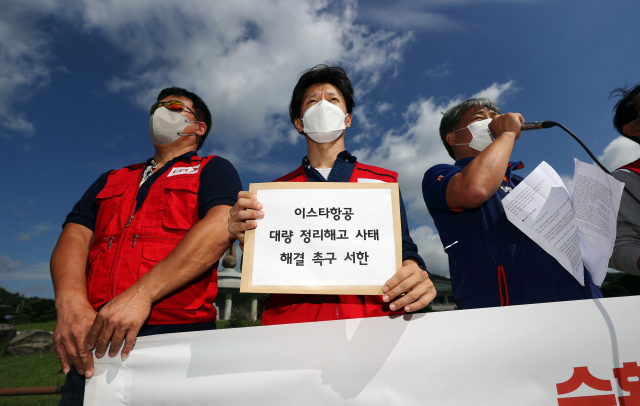 8일 오전 서울 종로구 청와대 사랑채 앞에서 열린 이스타항공 대량 정리해고 통보 규탄 기자회견에서 민주노총 전국공공운수노동조합 관계자가 손팻말을 들고 있다. 연합뉴스