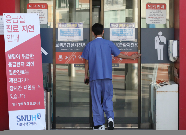 전공의들이 집단휴진을 벌인 지 18일 만에 업무에 복귀한 8일 서울 종로구 서울대학교병원에서 의료진이 응급의료센터로 들어가고 있다. 연합뉴스