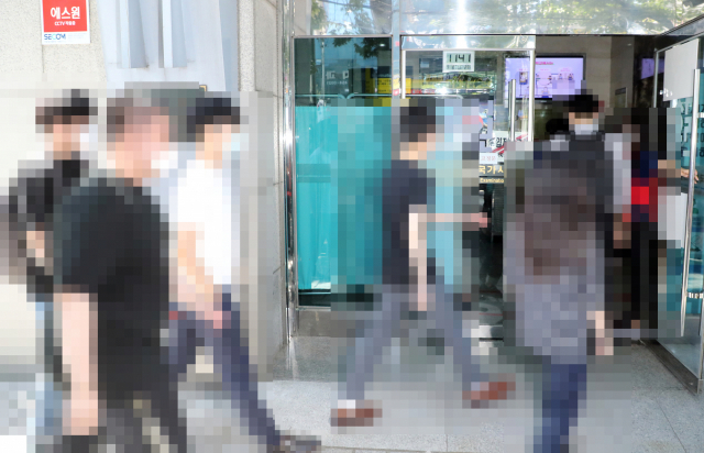 2021년도 제85회 의사국가시험 실기시험 첫날인 8일 서울 광진구 한국보건의료인국가시험원으로 응시생과 관계자들이 섞여 들어가고 있다. 국시원 측은 응시생들의 신원 노출을 우려해 시험장 주변에 대기한 관계자들과 응시생을 섞어서 함께 입장시켰다. 연합뉴스