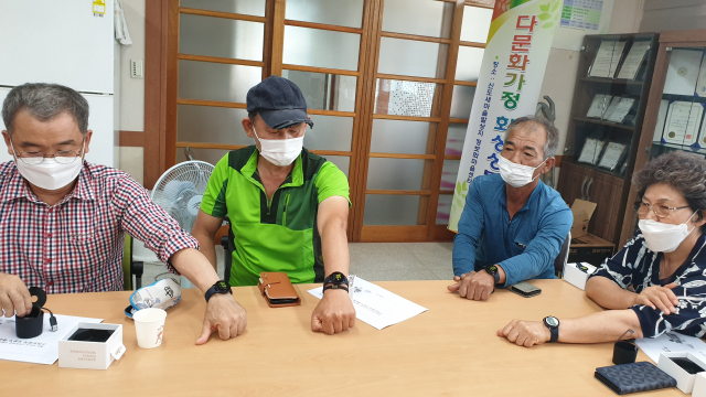청도군이 8일 스마트타운 시범마을인 청도읍 신도리 주민에게 건강을 챙길 수 있도록 전달한 스마트워치를 주민들이 들어보이고 있다. 청도군 제공