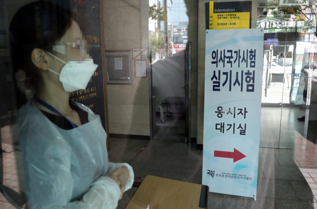 2021년도 제85회 의사국가시험 실기시험 둘째날인 9일 서울 광진구 한국보건의료인국가시험원에서 관계자가 응시생의 발열검사를 위해 대기하고 있다. 연합뉴스