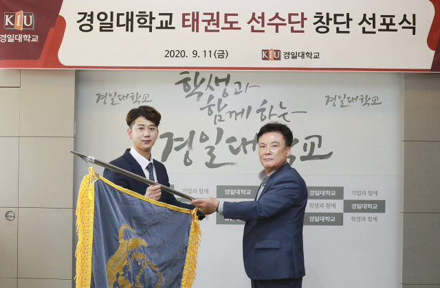 정현태 경일대 총장이 손태진 감독에게 KIU스포츠단기를 전달하고 있다. 경일대 제공