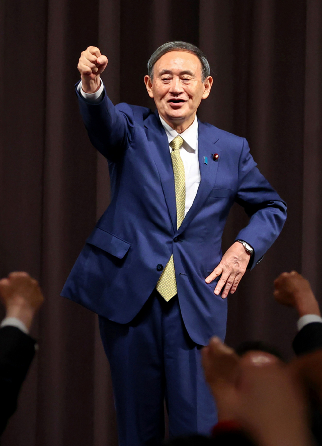 스가 요시히데 일본 관방장관이 14일 자민당 총재 선거에서 지지자들에게 주먹을 불끈 쥐어보이고 있다. 연합뉴스