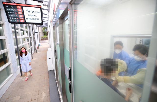 16일 오후 서울 서초구보건소에 마련된 코로나19 언택트 선별진료소를 찾은 시민이 검사를 받고 있다. 연합뉴스