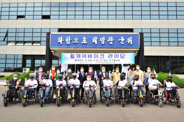대구지체장애인협회 동구지회 회원들이 17일 군위군에서 휠체어바이크 라이딩을 하고 종착지인 군위군청에서 기념촬영을 하고 있다. 군위군 제공