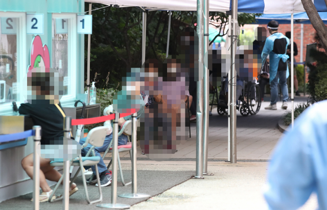 17일 서울의 한 보건소 선별진료소가 코로나19 검사를 받으려는 시민들로 붐비고 있다. 연합뉴스