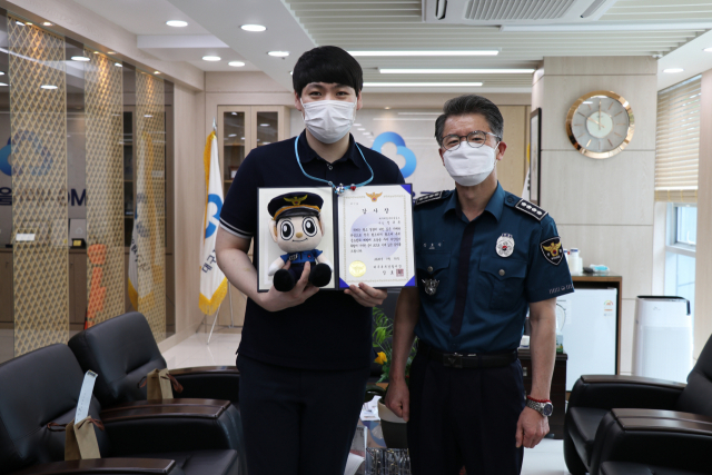 장호식 대구북부경찰서장이 18일 오전 대구 북구 노원동 제일새마을금고에서 보이스피싱 피해를 예방한 직원 정규돈(28) 씨에게 감사장을 수여했다. 대구북부경찰서 제공