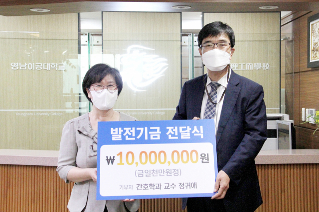 정귀애 영남이공대 명예교수가 박재훈 총장에게 발전기금을 전달하고 있다. 영남이공대 제공