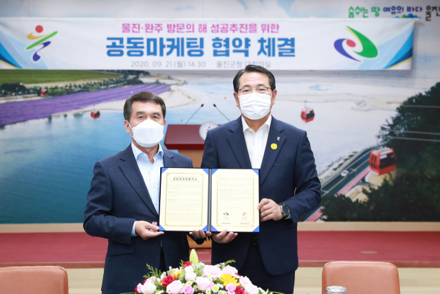 전찬걸(오른쪽) 울진군수와 박성일 완주군수가 21일 공동마케팅을 위한 업무협약을 체결하고 있다. 울진군 제공