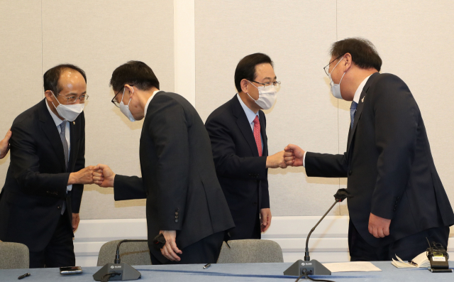 더불어민주당 김태년 원내대표(오른쪽)와 국민의힘 주호영 원내대표(오른쪽 두번째)가 22일 국회에서 2020년도 제4차 추가경정예산안 합의사항 발표에 참석,악수하고 있다. 연합뉴스
