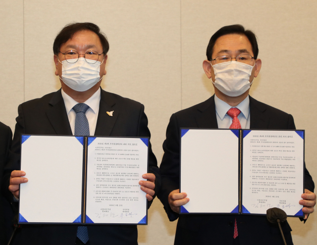 더불어민주당 김태년 원내대표와 국민의힘 주호영 원내대표가 22일 국회에서 2020년도 제4차 추가경정예산안 합의사항 발표에서 합의문에 서명한 뒤 기념촬영을 하고 있다. 연합뉴스