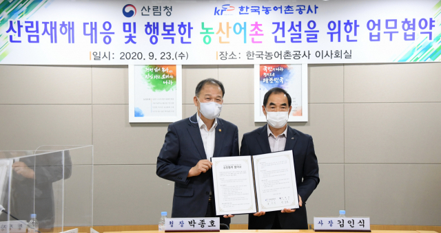 박종호 산림청장(왼쪽)과 김인식 한국농어촌공사 사장이 23일 전남 한국농어촌공사 회의실에서 산림재해 대응 및 행복한 농산어촌 건설을 위한 업무협약을 체결한 뒤 기념촬영을 하고 있다. 산림청 제공