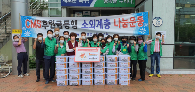 대구 북구 구암동 새마을협의회와 부녀회 회원들이 23일 행정복지센터 앞에서 맞춤형 선물꾸러미 전달식을 가졌다. 북구청 제공