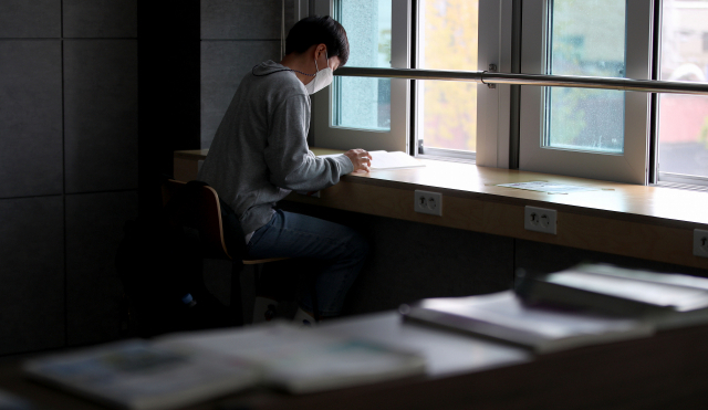 코로나19 장기화 여파로 대구경북지역 취업 준비생들의 불안감이 커지고 있다. 24일 취준생 A씨가 동구 한 도서관에서 마스크를 쓴 채 공부를 하고 있다. 김영진 기자 kyjmaeil@imaeil.com