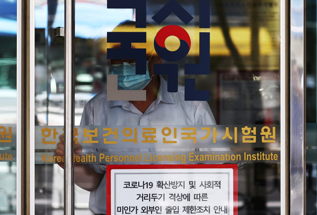 전국 의과대학 본과 4학년생들이 기존의 입장을 바꿔 국가고시 응시 의사를 표시한 24일 자양동에 위치한 한국보건의료인국가시험원(국시원)에 관계자가 출입구를 관리하고 있다. 연합뉴스