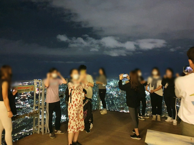 지난 23일 오후 7시 30분쯤 찾은 대구 남구 앞산전망대. 레깅스를 입은 젊은이들이 등반을 마치고 전망대에서 인증샷을 찍고 있다. 배주현 기자