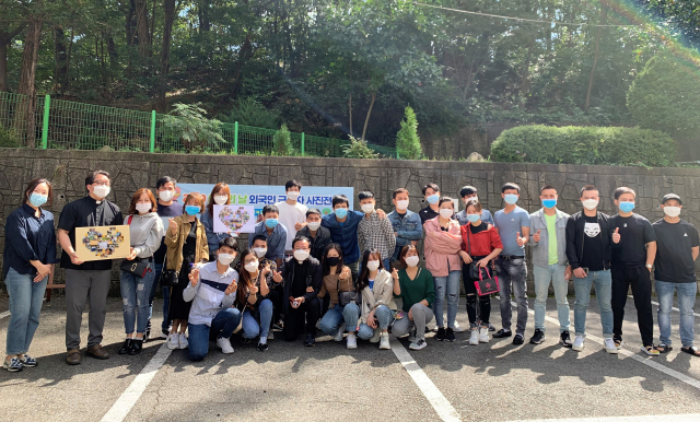 구미가톨릭문화센터에서 구미지역 외국인 근로자들이 사진전을 하며 기념촬영을 하고 있다. 구미가톨릭문화센터 제공