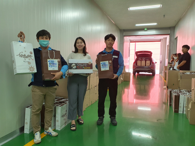 경북 구미 아주스틸㈜ 임직원들이 추석 선물로 받은 구미 무을의 참나무 표고버섯을 들고 기념촬영을 하고 있다. 아주스틸 제공