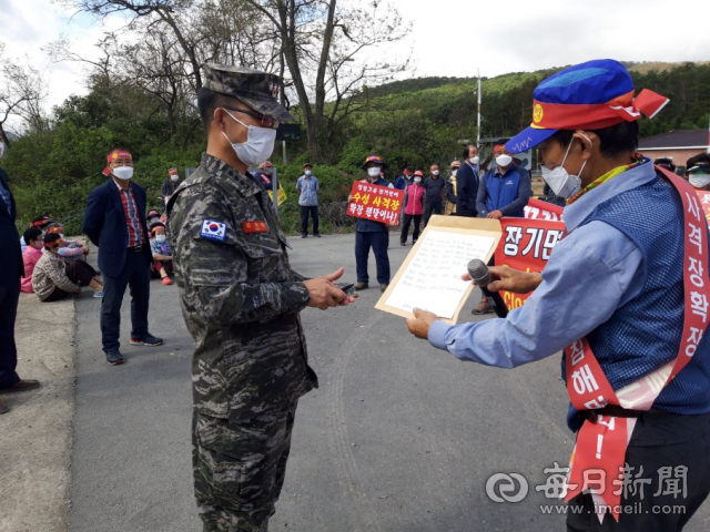 주한 미군 헬기 사격장으로 쓰이고 있는 포항시 남구 장기면 수성사격장 인근 주민들이 사격장 이전 또는 완전 폐쇄를 요구하는 주민 항의문을 해명대에 전달하고 있다. 포항시 제공